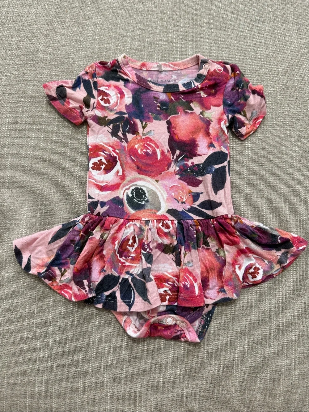 Posh Peanut twirl bodysuit features a Dusk Rose floral print 0-3M